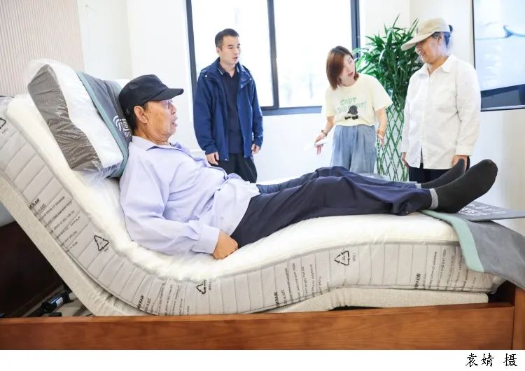 图为工作人员正在向前来咨询体验的老人介绍适合适老化改造的设施,以及适用于老年人使用的各类扶手及家具电器。/文汇报记者袁婧摄 图片